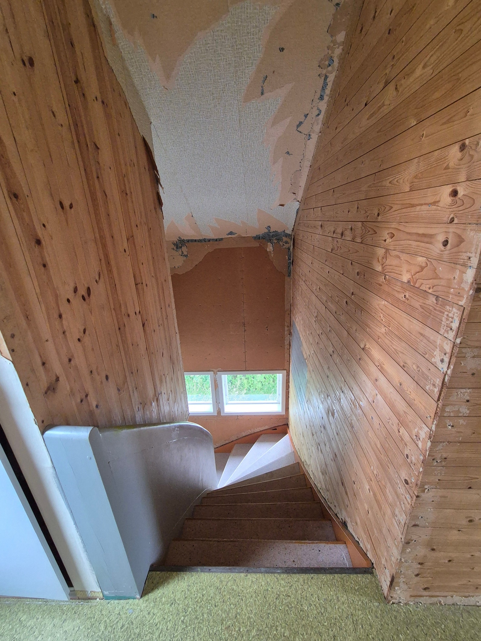 Trapp ned fra loft. Gammel tapet er delvis fjernet og det er planlagt maling av panel Galleribilde