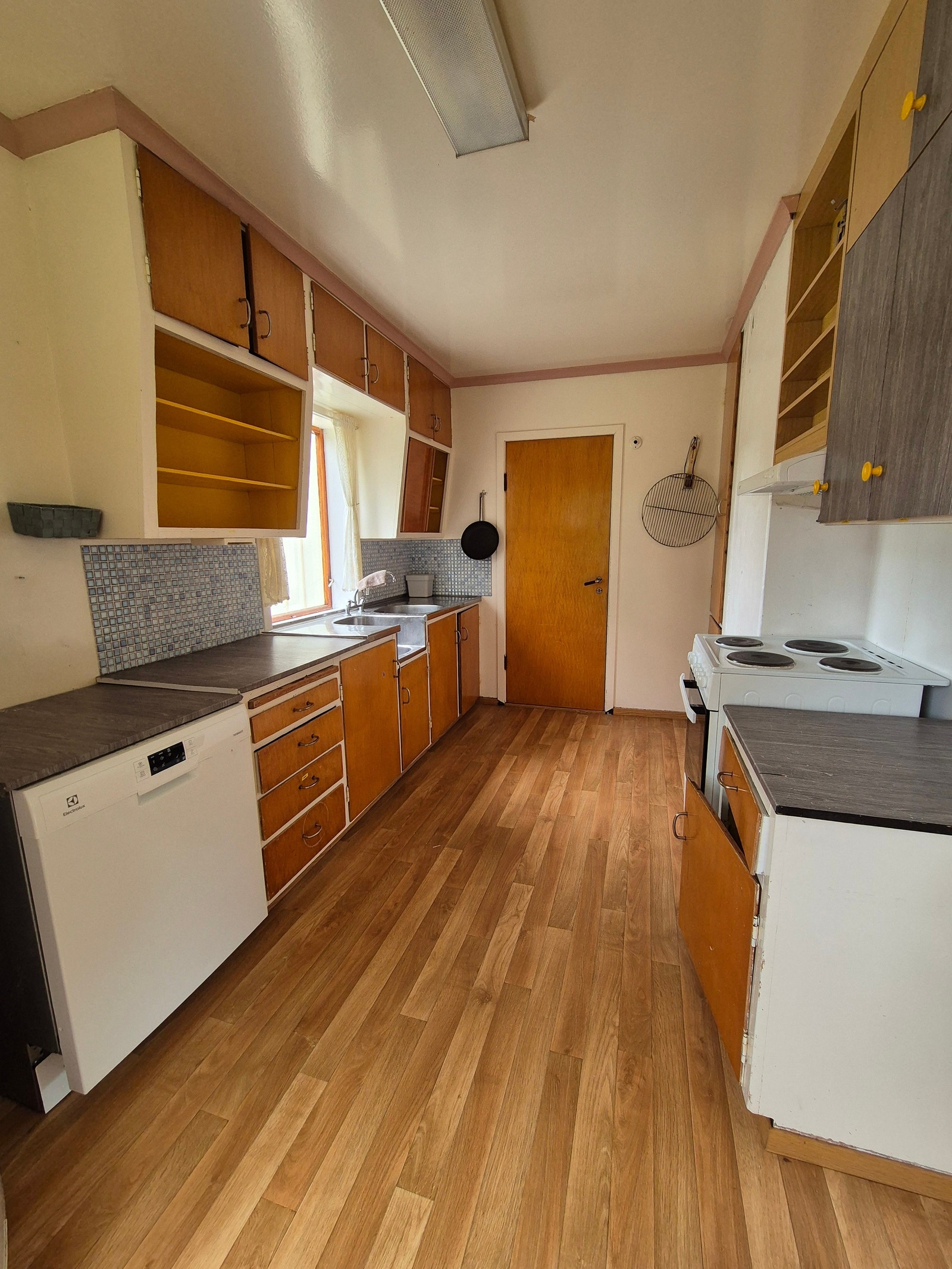 Kjøkken med eldre kjøkkeninnredning og oppvaskmaskin Galleribilde