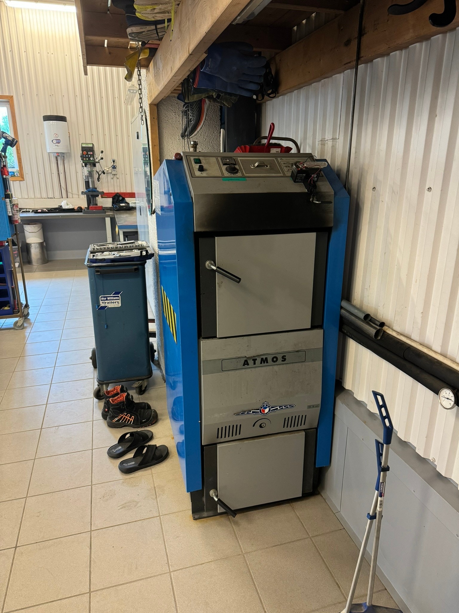 Komplett 75kw vedkjele anlegg m/ 3000l akkumulatortank og regulerinssystem som varmer opp verksted og boder i garasje. Kulvertrør inn til boligen for å varme opp denne med energien fra vefyringen i verksted er gravd ned og gjort klar. Galleribilde