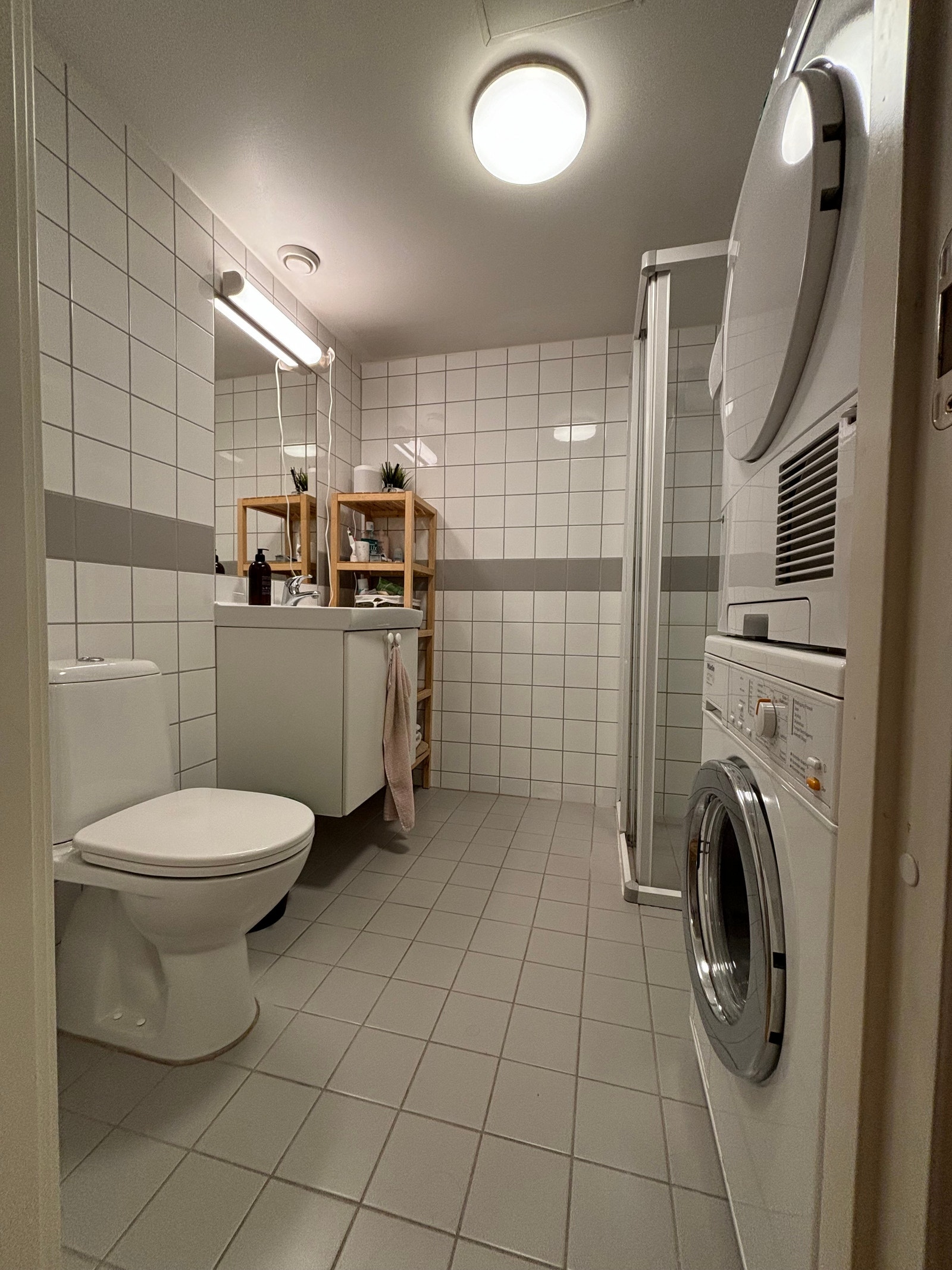 Bad med toalett, dusj, vaskemaskin og tørketrommel Galleribilde