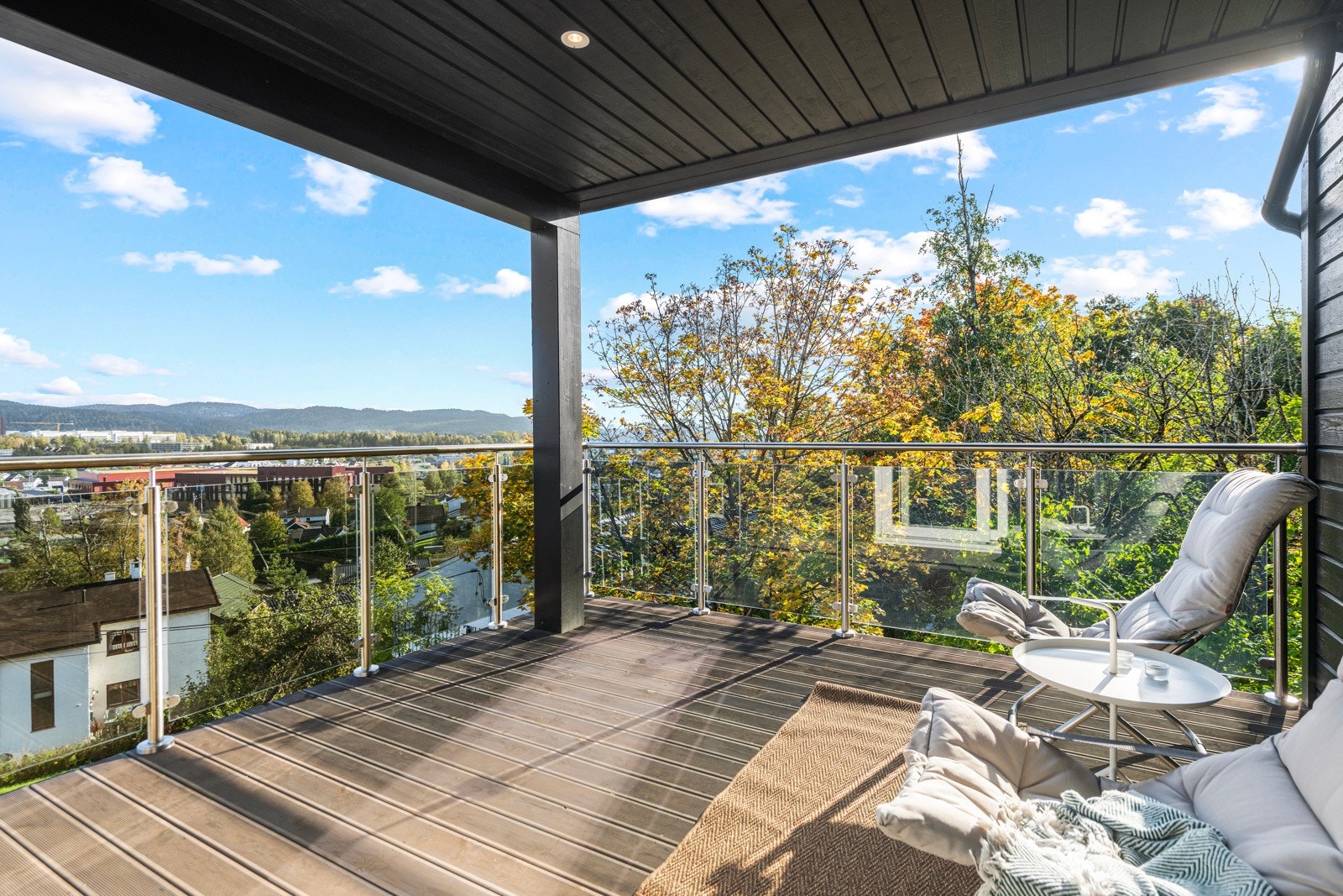 Fra stuen i 2.etasje er det utgang til en overbygget balkong med glassrekkverk og downlights i himlingen Galleribilde