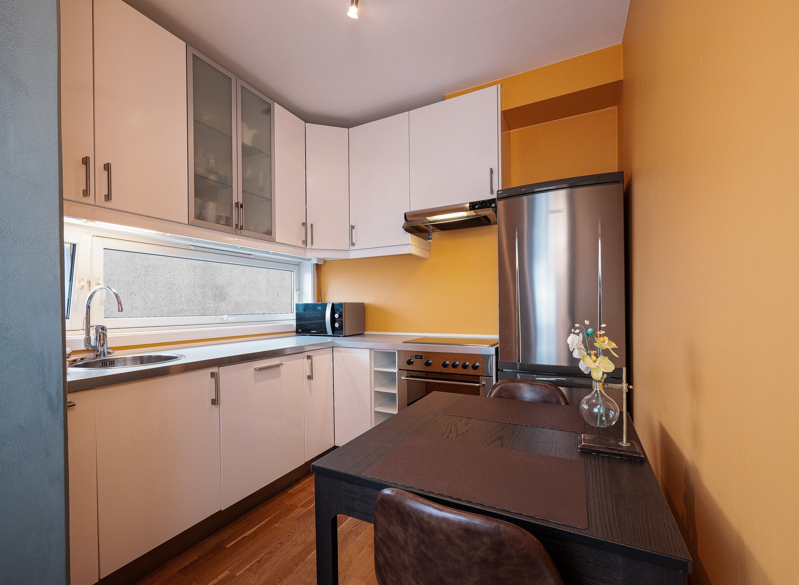 Romslig kjøkken med plass til bord og to stoler Galleribilde