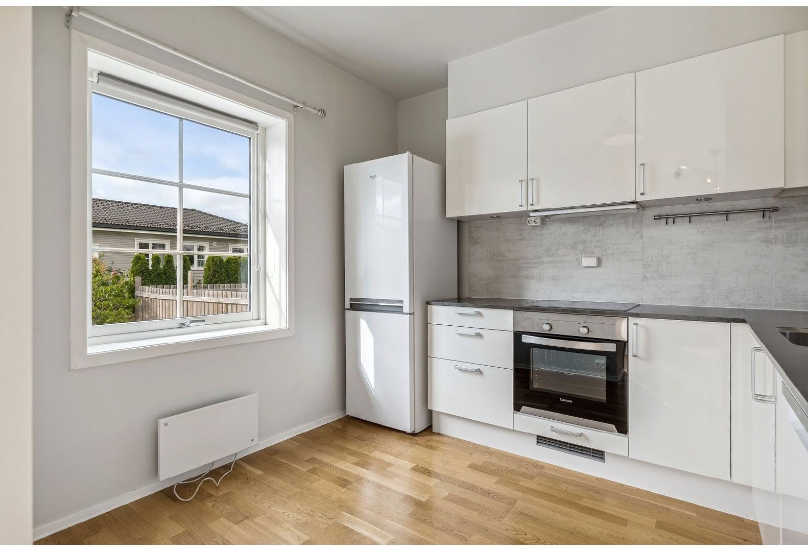 Nyere kjøkken med både intergrerte og frittstående hvitevarer. Galleribilde