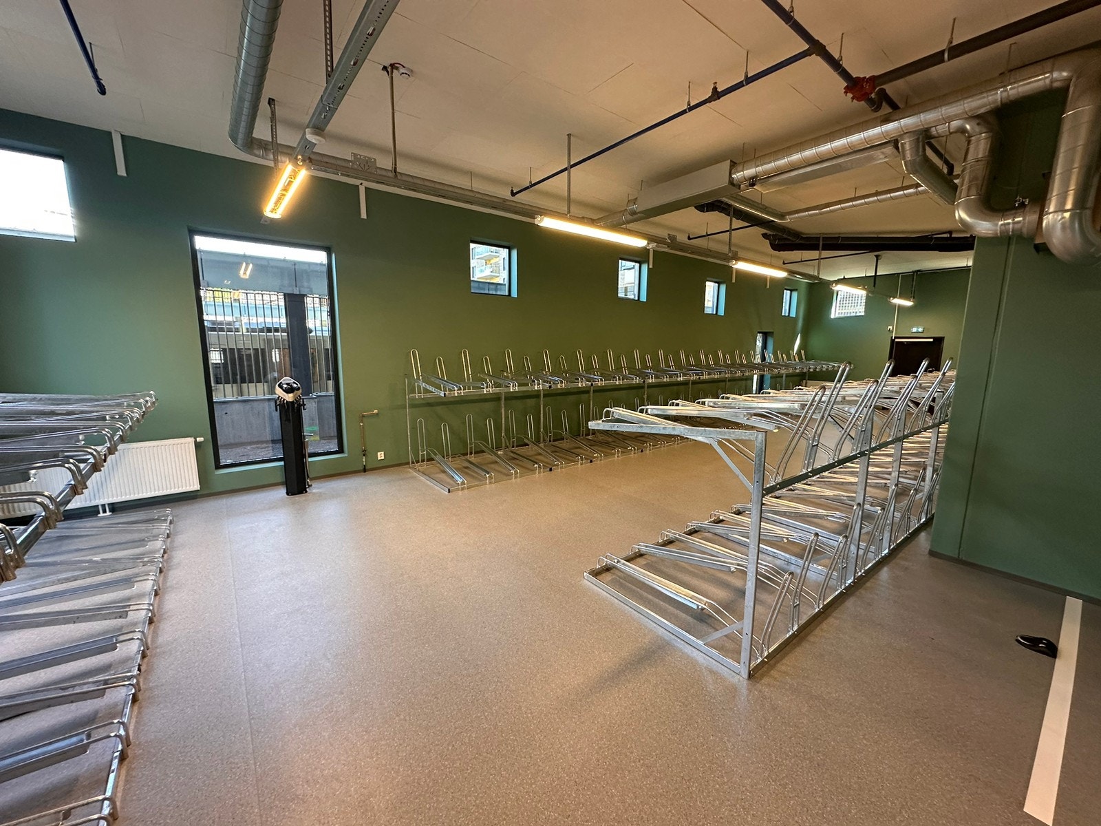 stor sykkelparkering med dusj og lader til e-sykkel batteri. Galleribilde