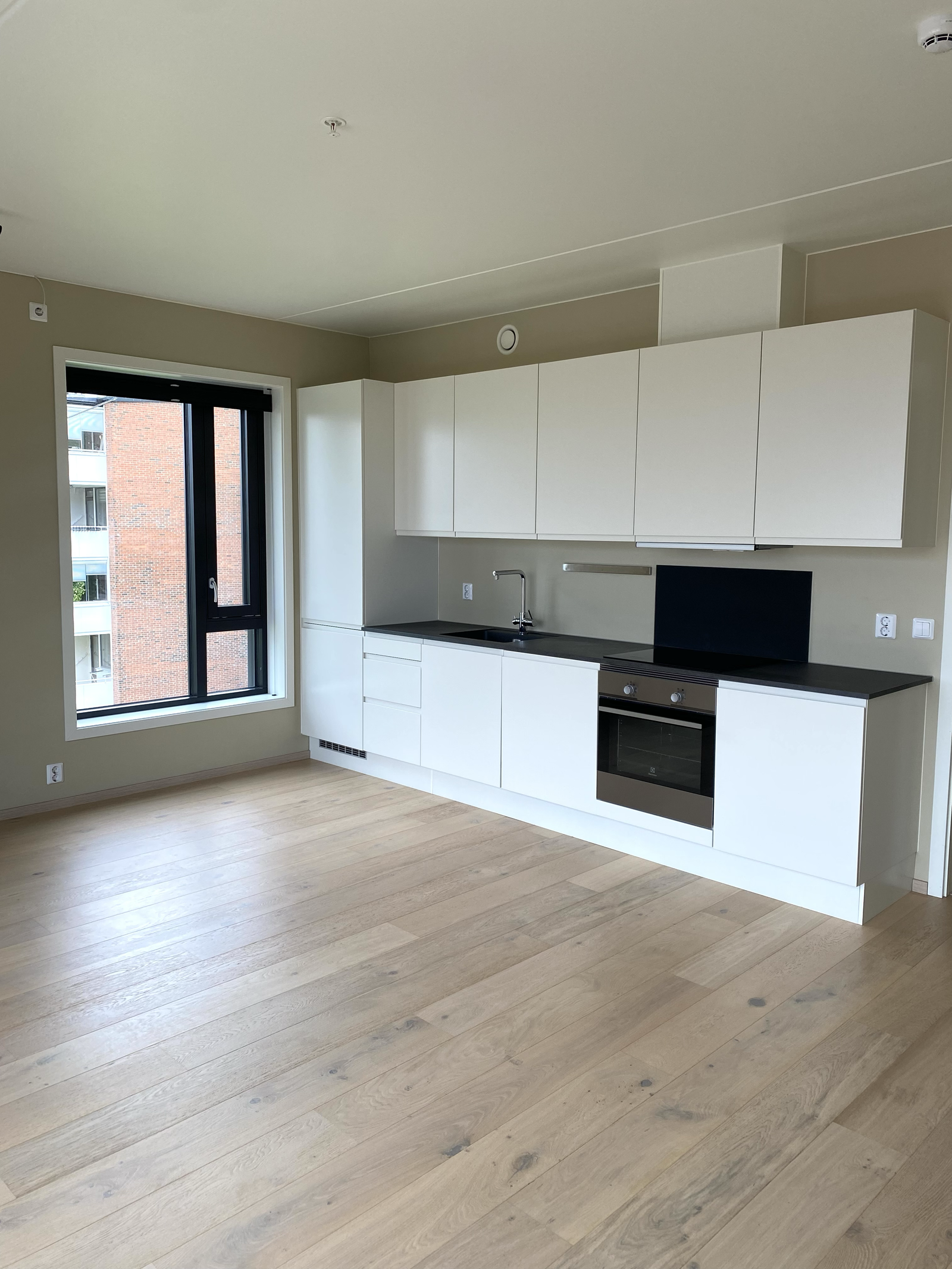 HTH-kjøkken med Electrolux hvitevarer (kjøleskap, ovn, induksjonstopp) og komfyrvakt Galleribilde