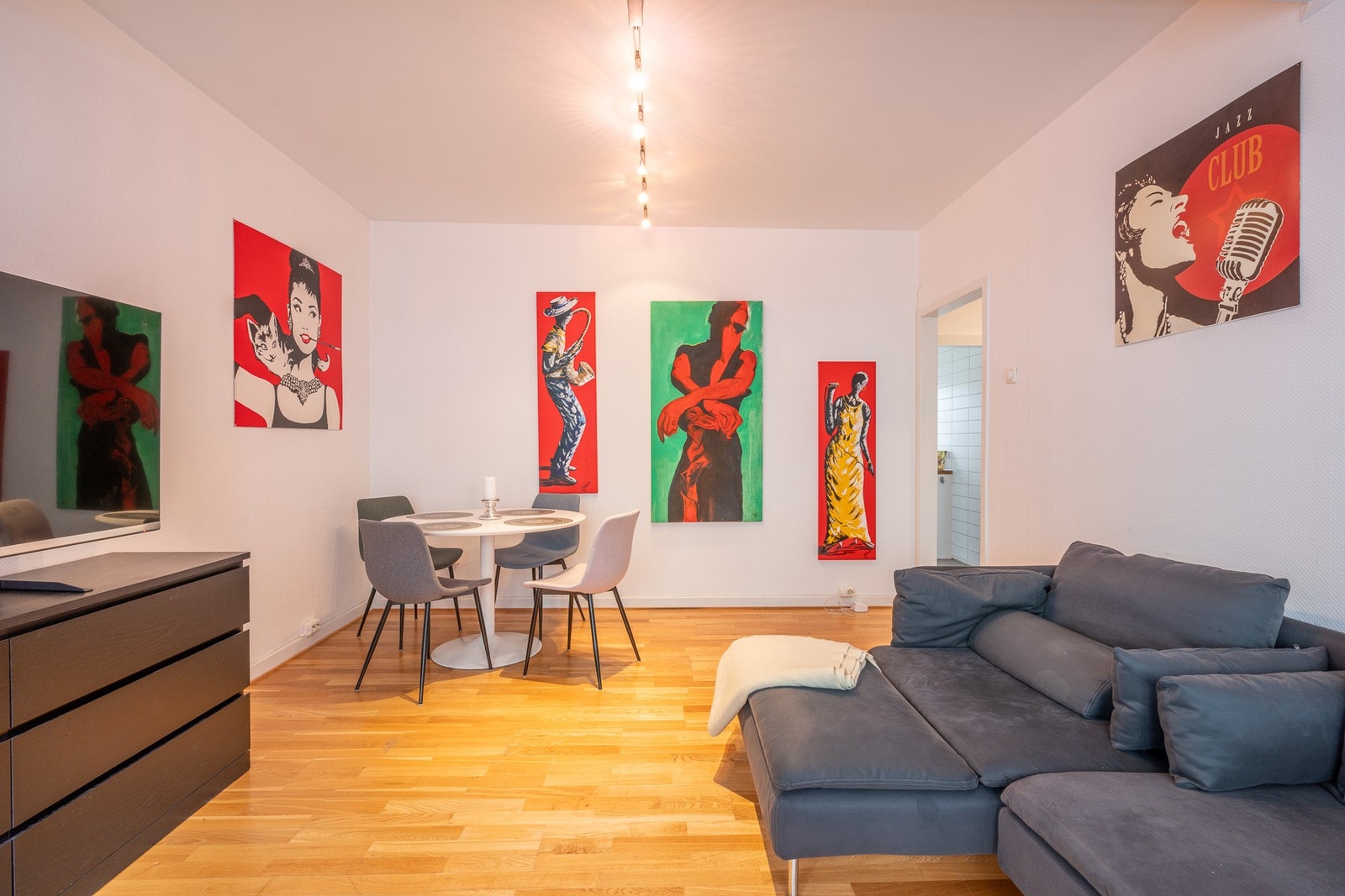 Stue med spiseplass, sofa med sjeselong og stor TV Galleribilde