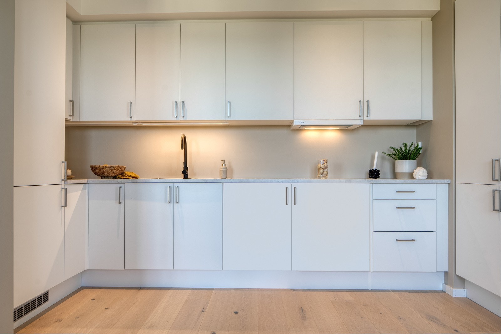 Kjøkken er levert av HTH med glatte, hvite overflater. Benkeplater 30mm med underlimt oppvaskkum av stål. Galleribilde