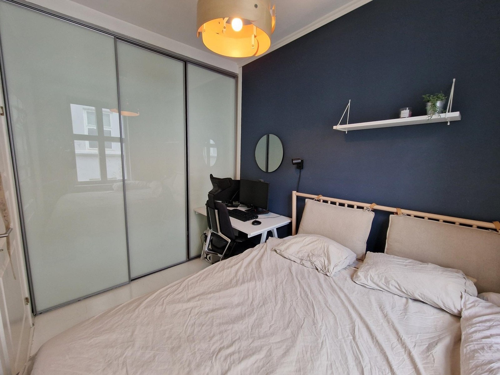 Soverommet er møblert med et stort klesskap, skrivepilt med kontorstol og dobbeltseng Galleribilde