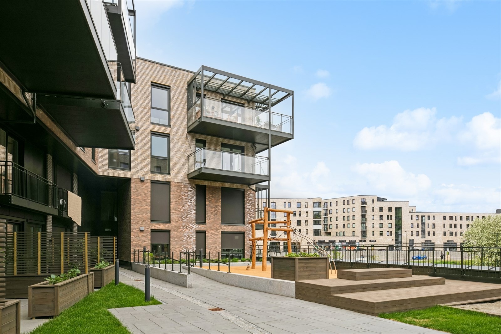 Trivelige og solrike fellesområder mellom byggene. Galleribilde