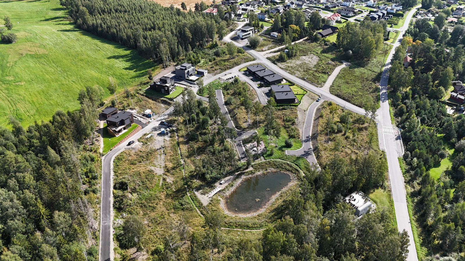 Oversiktsbilde fra område. Merk dammen og lekeplassen på området.