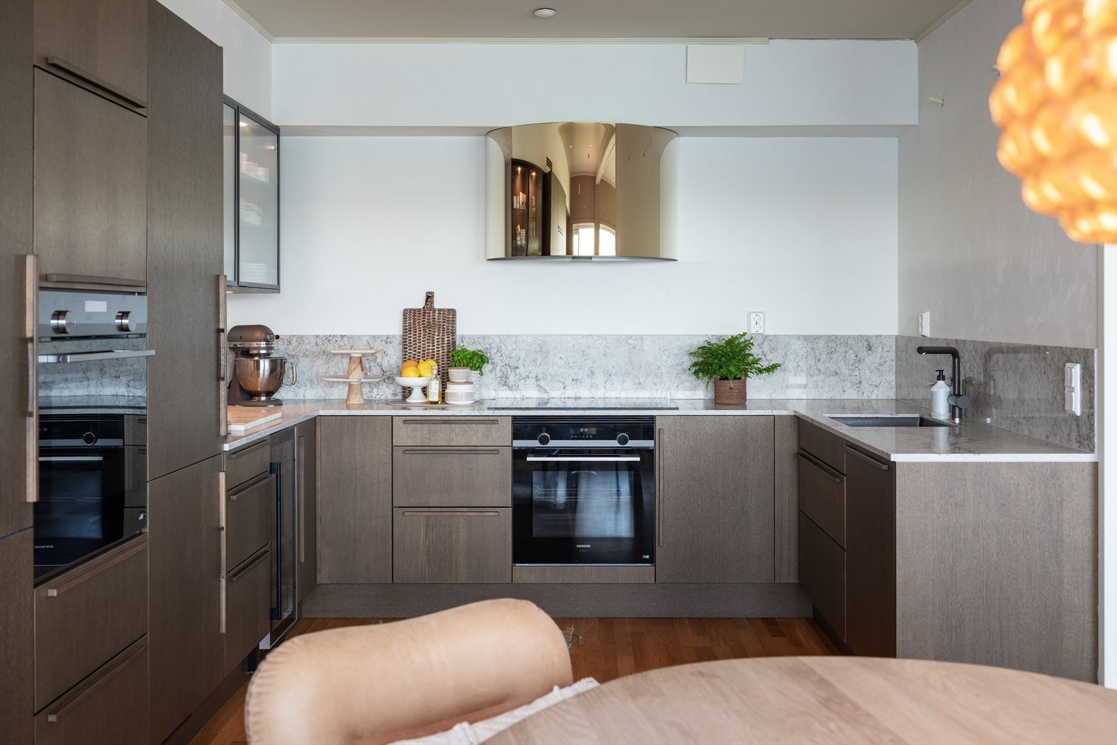 Kjøkkenet fra HTH er velutstyrt med blant annet to integrerte komfyrer, induksjonstopp, Røroshetta avtrekksvifte og integrert vinskap. Galleribilde