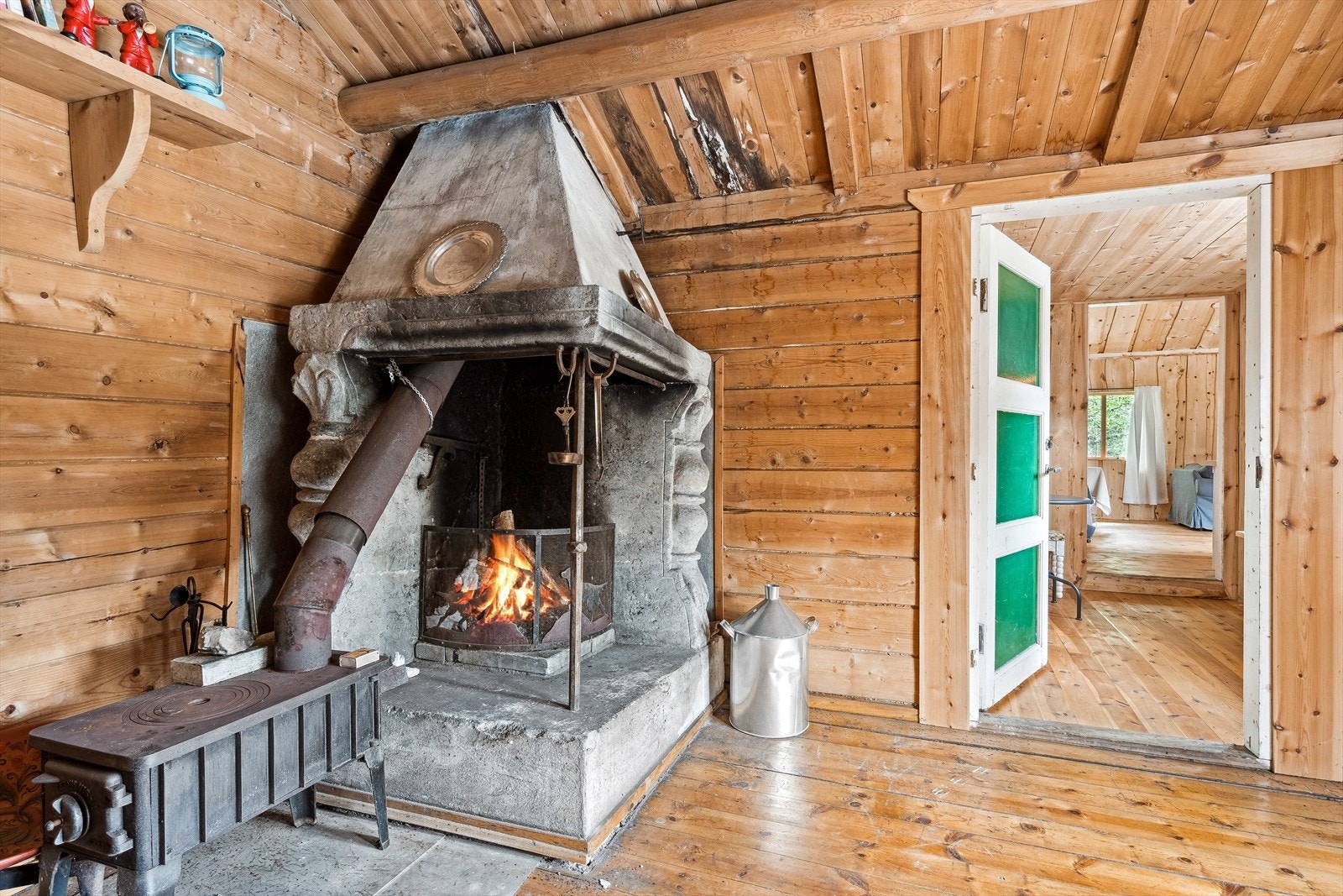 Den eldre delen av hytta inneholder en trivelig stue med stor åpen peis for oppvarming. Galleribilde