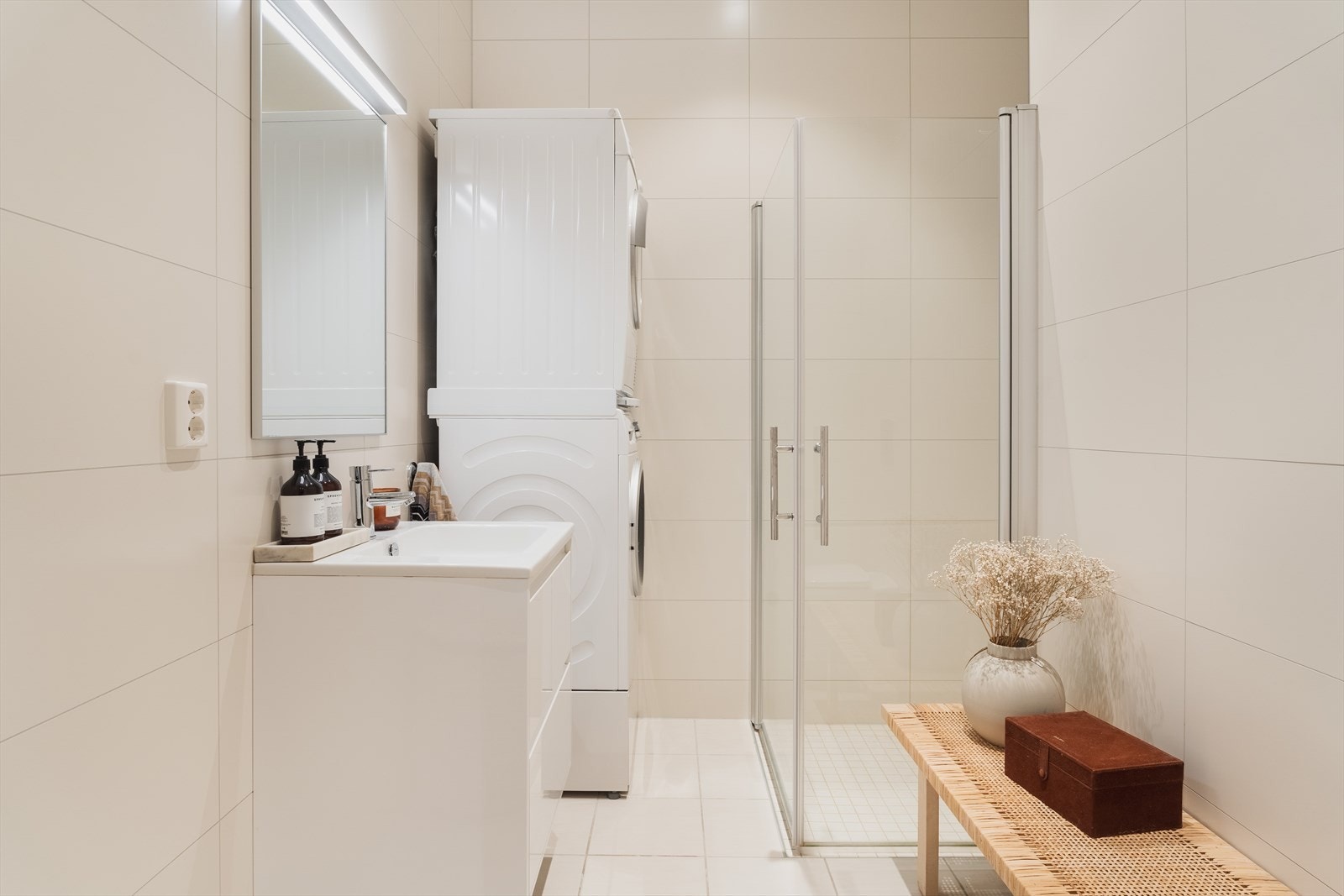 Badet har en praktisk innredning med servant og underskap som inneholder ett-greps blandebatteri Galleribilde