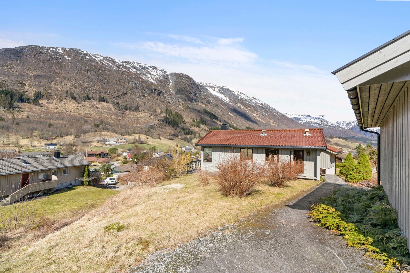 Rundt boligen er det opparbeida hage med plenarealer og beplantning Galleribilde
