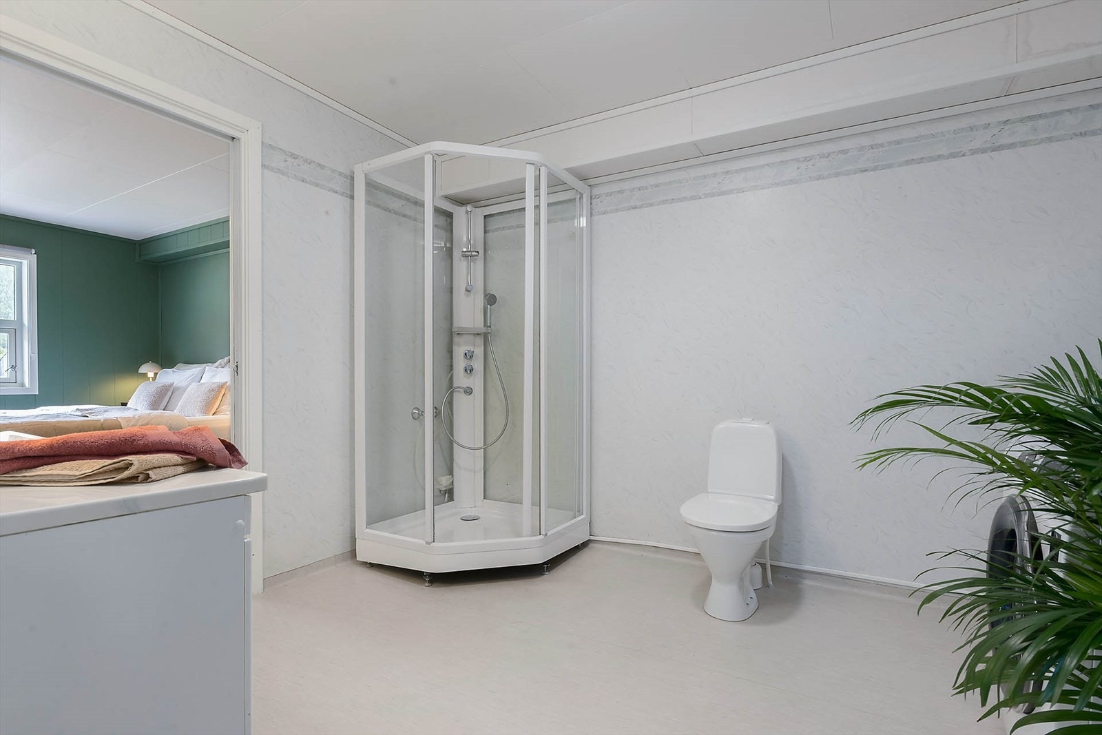 Rommet er innredet med dusjkabinett, toalett og opplegg for vaskemaskin, samt servant i underskap, overskap, speil, lysarmaturog stål skyllekar. Galleribilde