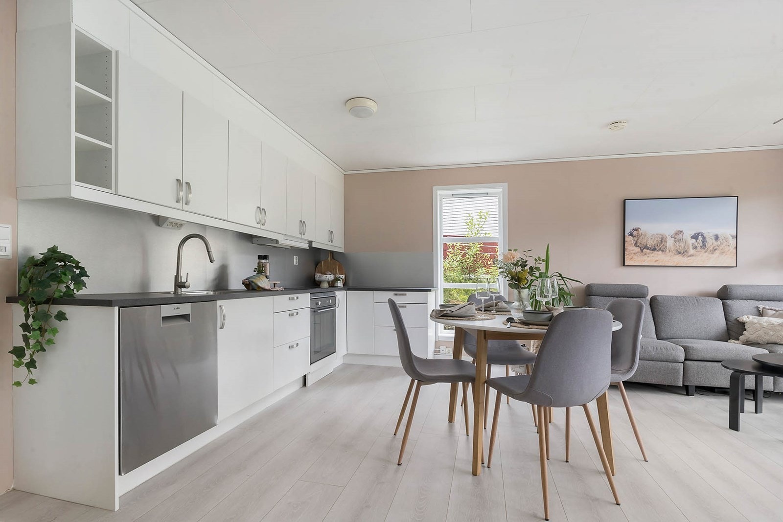 Stuen og kjøkkenet er i åpen løsning. Kjøkkenet er lyst og fint med glatte fronter og laminert benkeplate. Her er det godt med skap- og benkeplass. Galleribilde