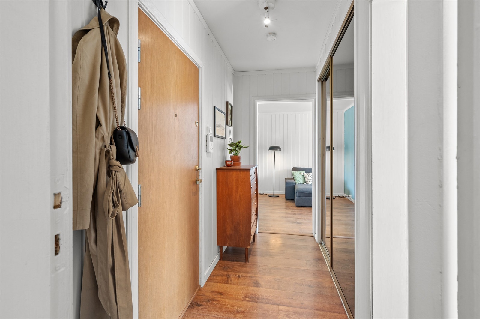 Fra entréen er det videre adkomst til samtlige av boligens oppholdsrom. Her er det også et stort skyvedørsgarderobe for oppbevaring av klær og diverse. Galleribilde