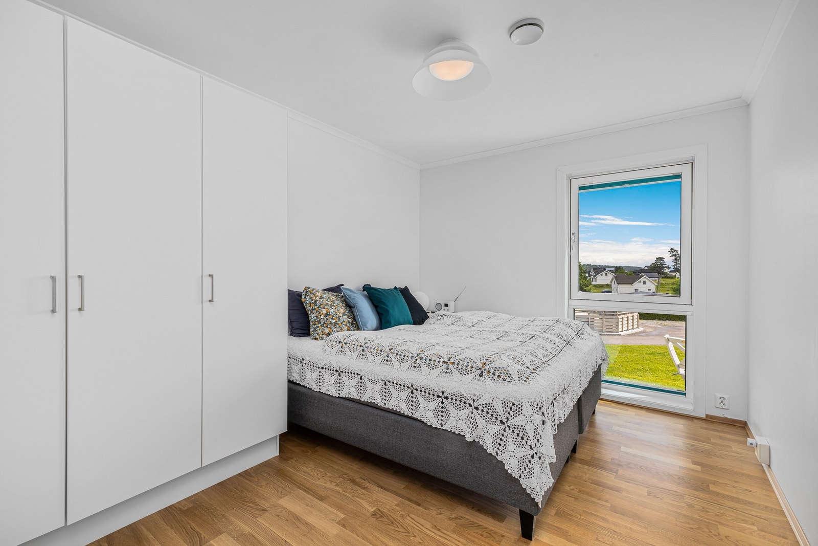 De lyse fargene i kombinasjon med stort vindu gjør så det allerede store soverommet føles større. Galleribilde