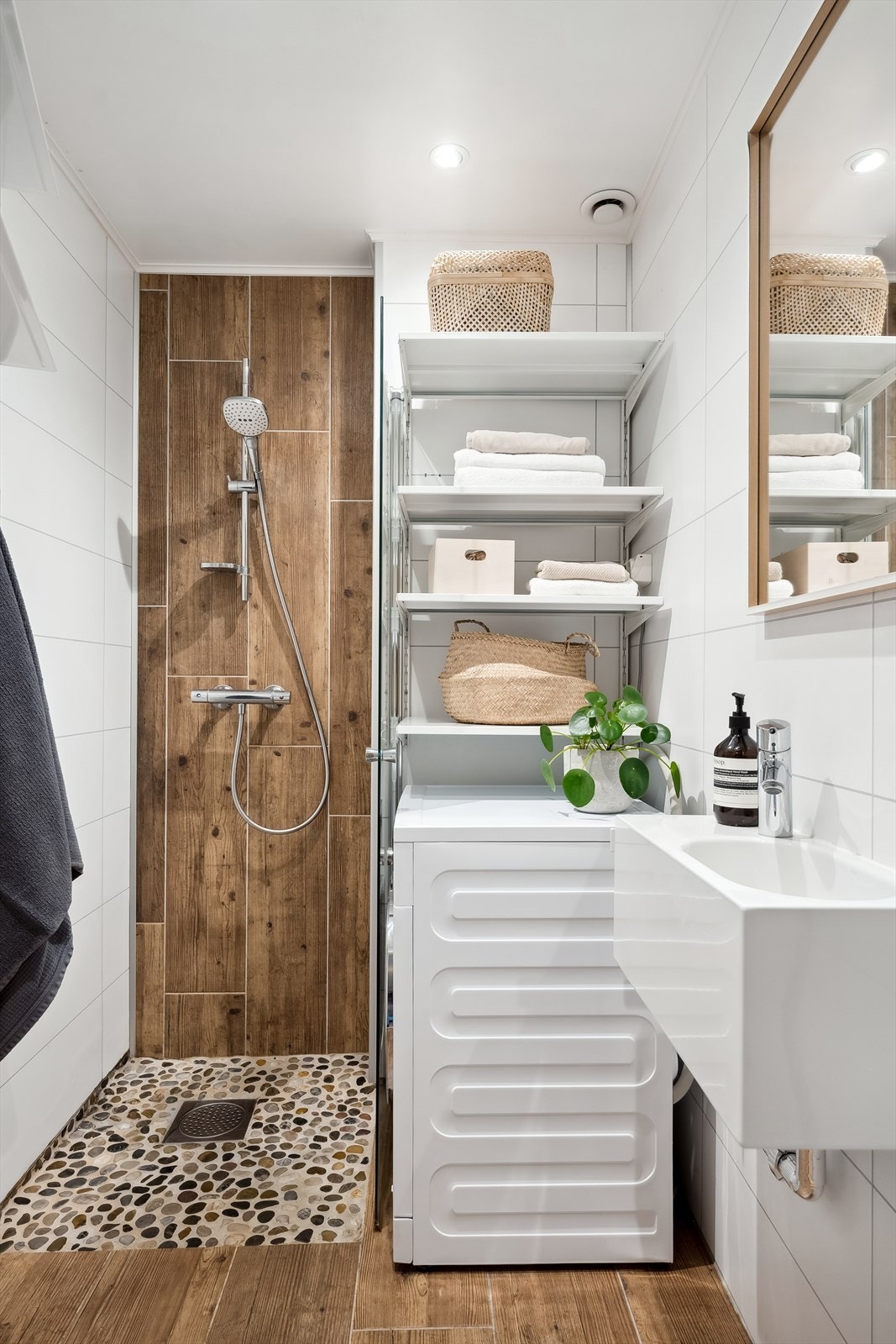 Innredningen består av dusj med innfellbar dør i herdet glass, servant og opplegg for vaskemaskin. Fastmontert hylleløsning. Galleribilde