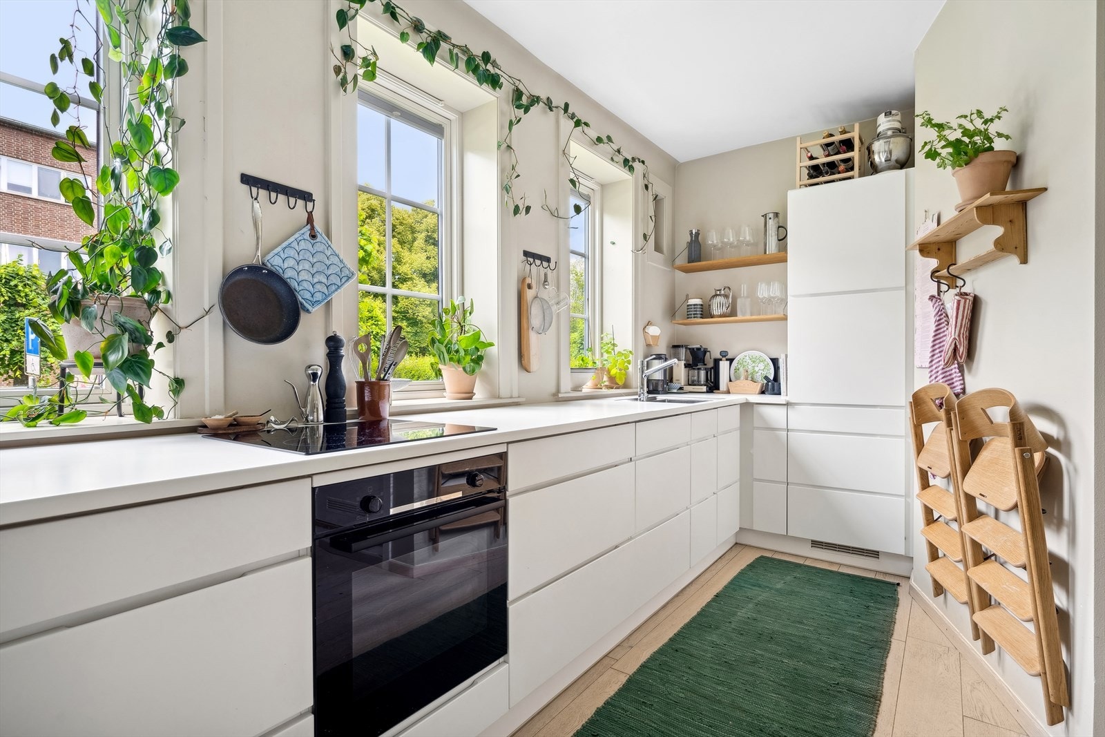 Den tidløse og moderne kjøkkeninnredning fra Kvik har glatte, hvite fronter og laminat benkeplate med nedfelt kum i rustfritt stål. Galleribilde