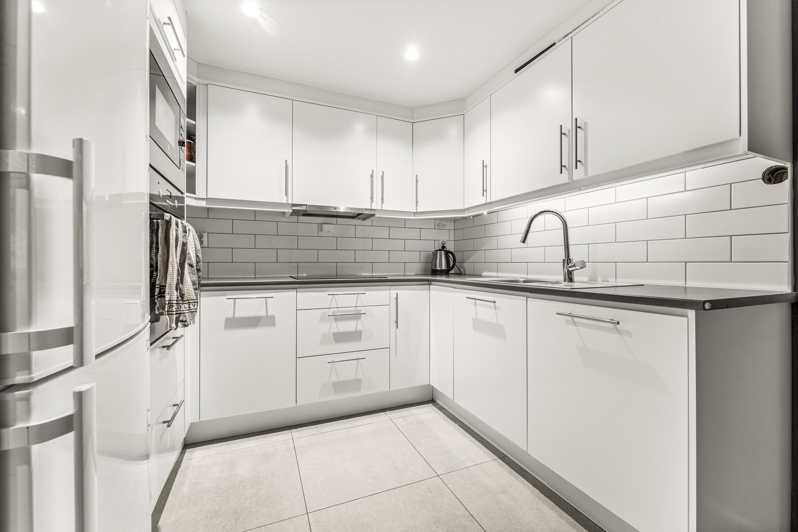 Kjøkkenet i utleiedelen har innredning med slette fronter og laminerte benkeplater Galleribilde