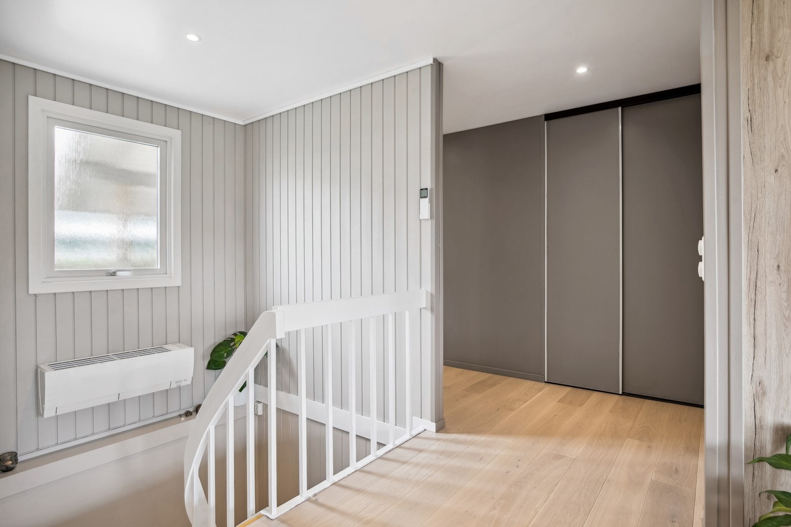 Gang med skyvedørsgarderobe. I trappen er det installert varmepumpe. Galleribilde
