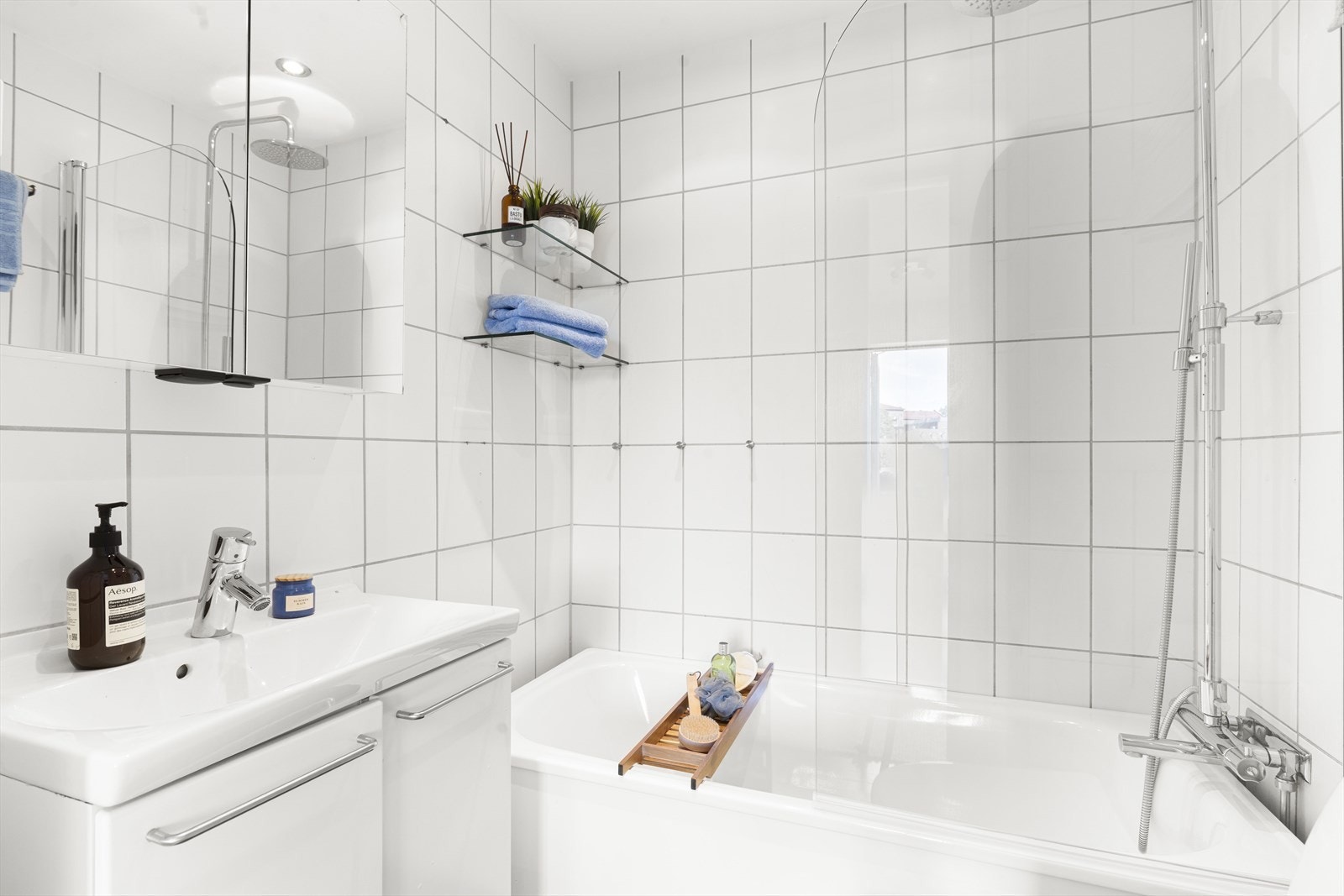 Badet er innredet med servantskap, speilskap, badekar med dusj og toalett Galleribilde