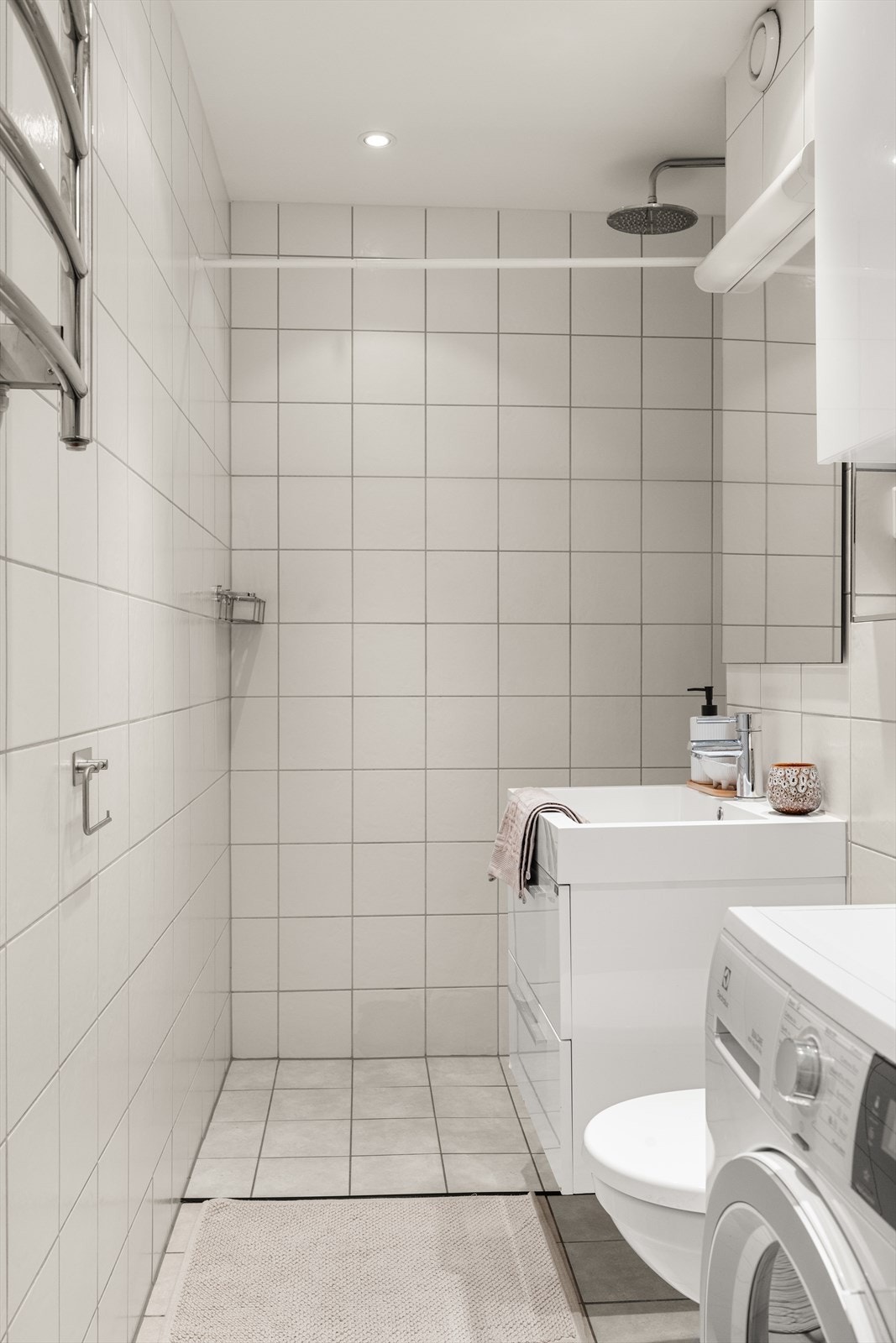 Flislagt bad med gulvvarme og opplegg for vaskemaskin. Galleribilde