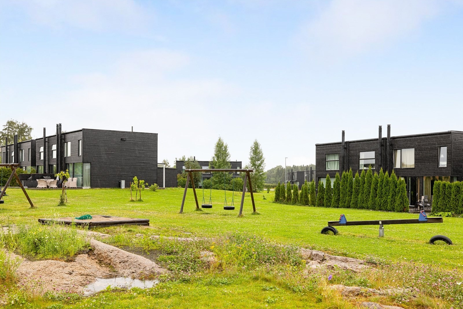 Fellesarealer består av plen med beplantning og gruslagt gårdsplass med parkering. Det er også flere lekeapparater for de minste beboerne i sameiet. Galleribilde