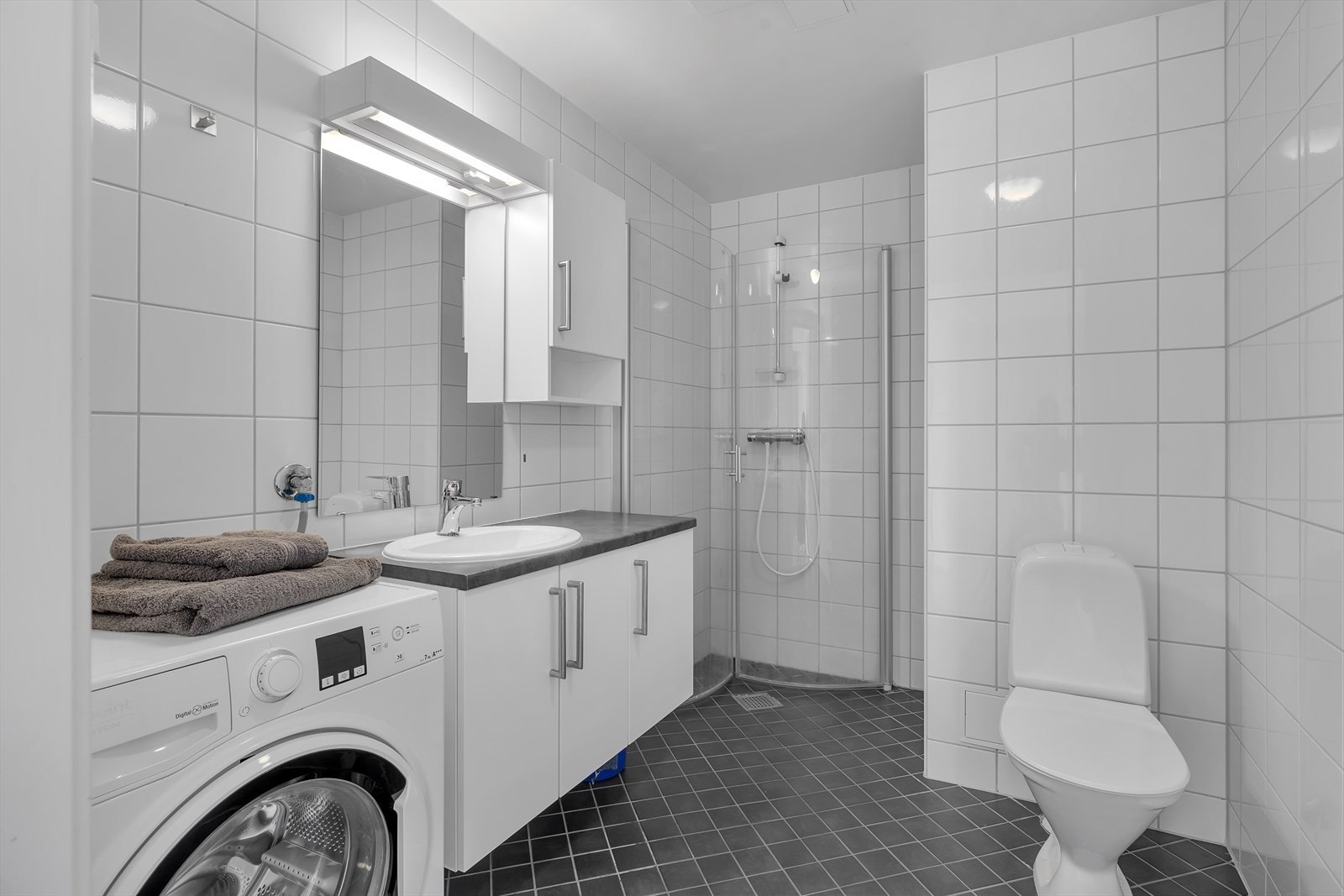 Baderommet har dusjnisje og god plass til vaskemaskin. Galleribilde