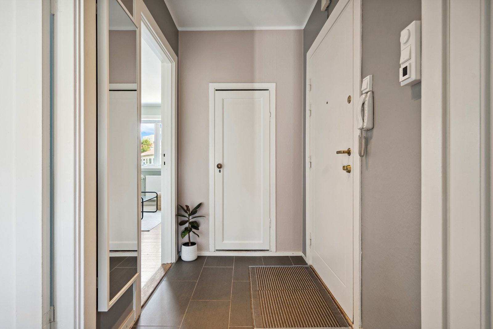 Innbydende og flislagt entré som gir et godt førsteinntrykk av leiligheten. Galleribilde