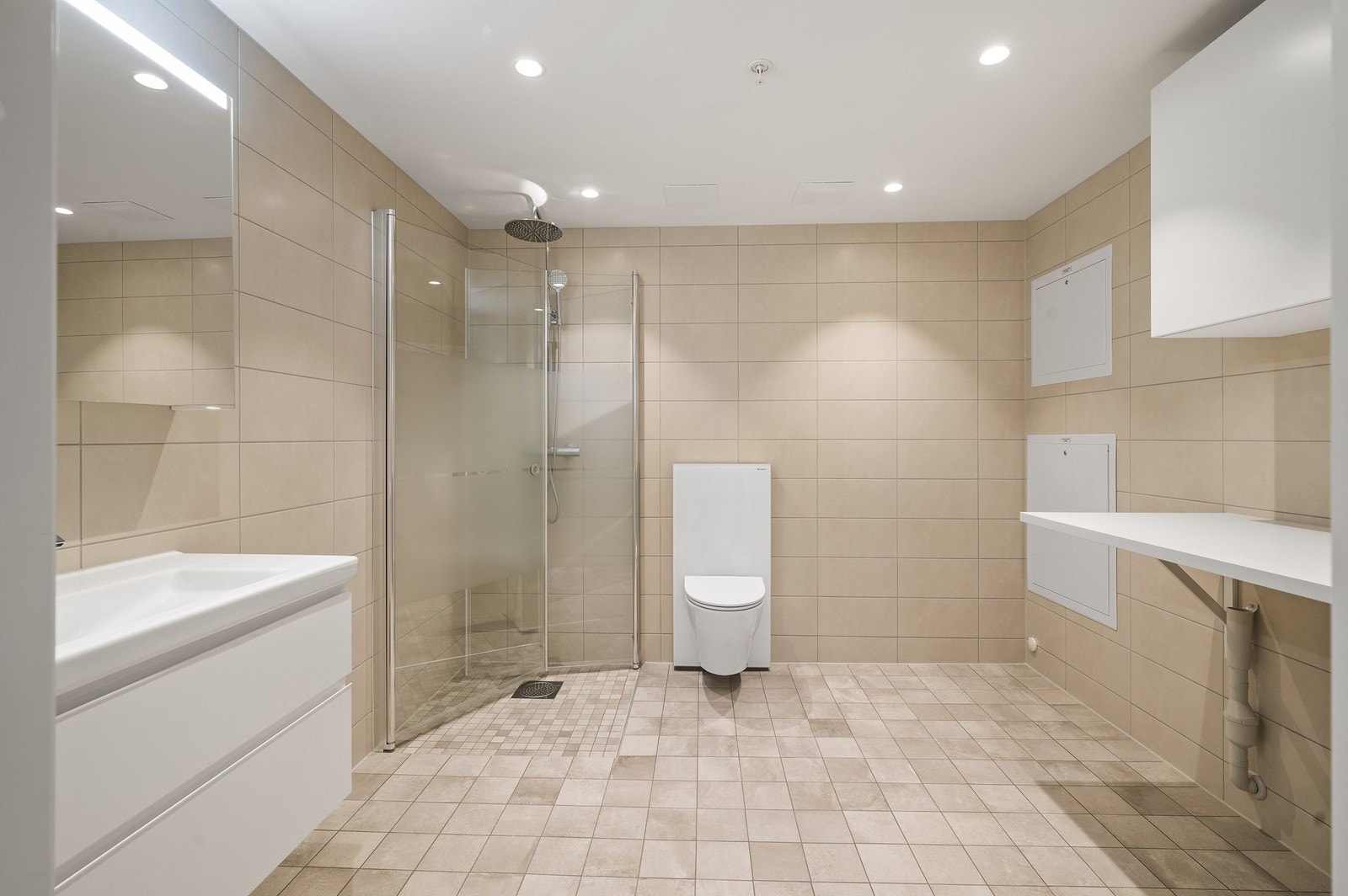 Romslig flislagt hovedbad med opplegg for vaskemaskin. Galleribilde