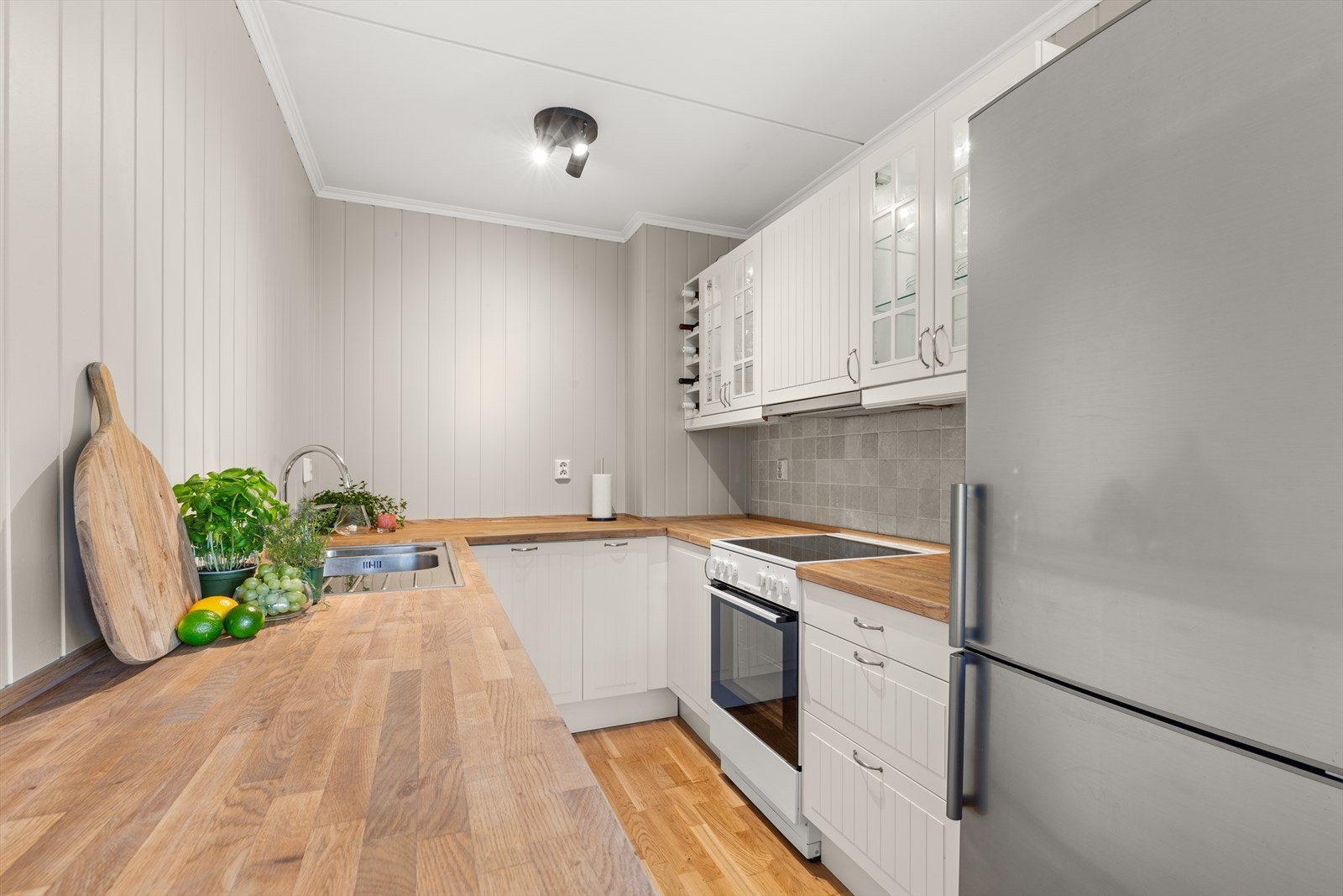 Stuen ligger i en delvis åpen løsning med kjøkkenet, men arbeidssonen er godt skjermet. Galleribilde