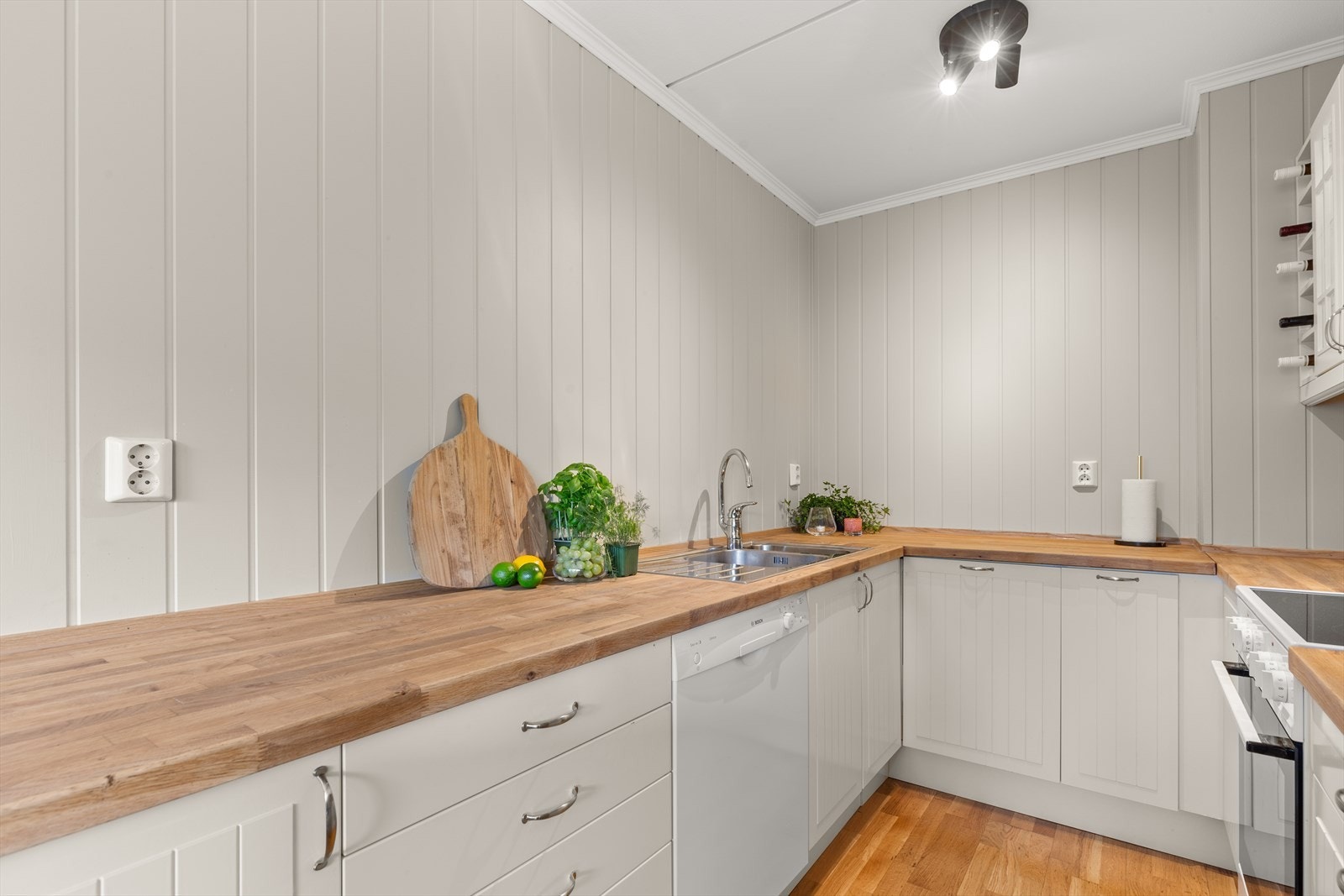 Kjøkkenet ligger åpent mot stuen, men likevel tilbaketrukket med skjermet arbeidssone. Innredningen er plassert parallelt langs to sider. Galleribilde