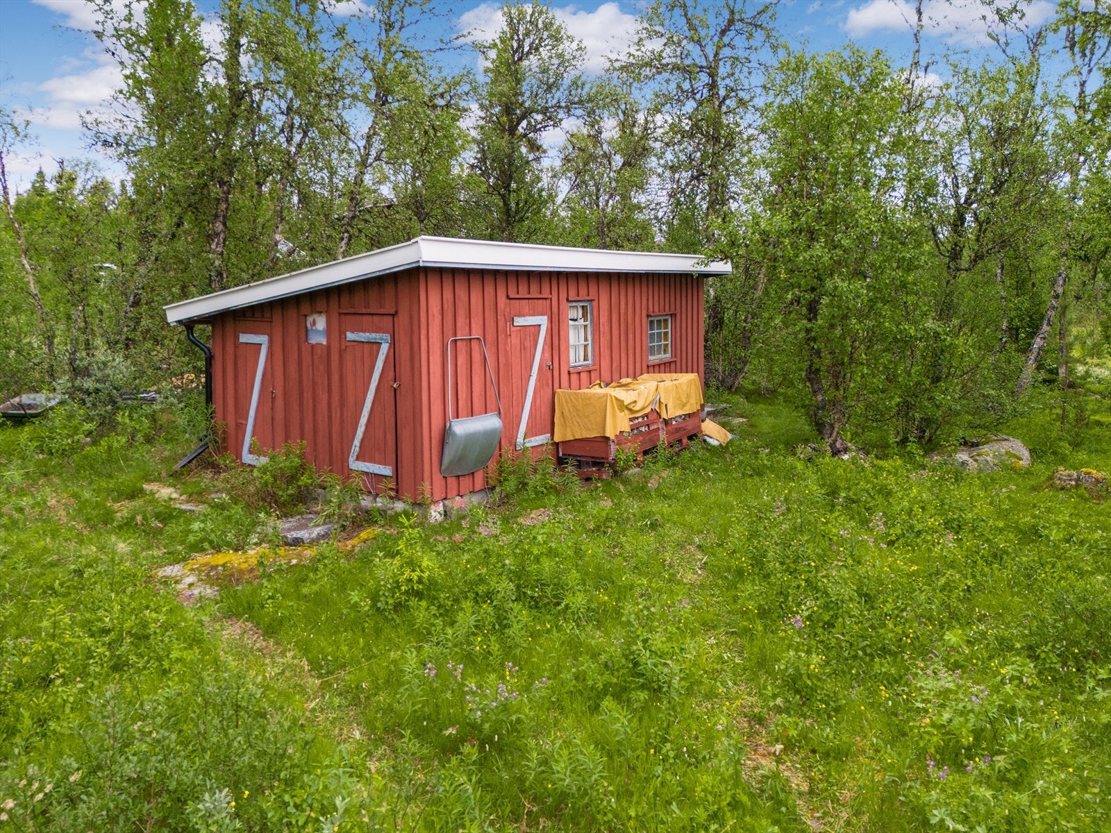 Uthus med flere rom. Det er både utedo, vedskjul, bod og gjesterom. Galleribilde