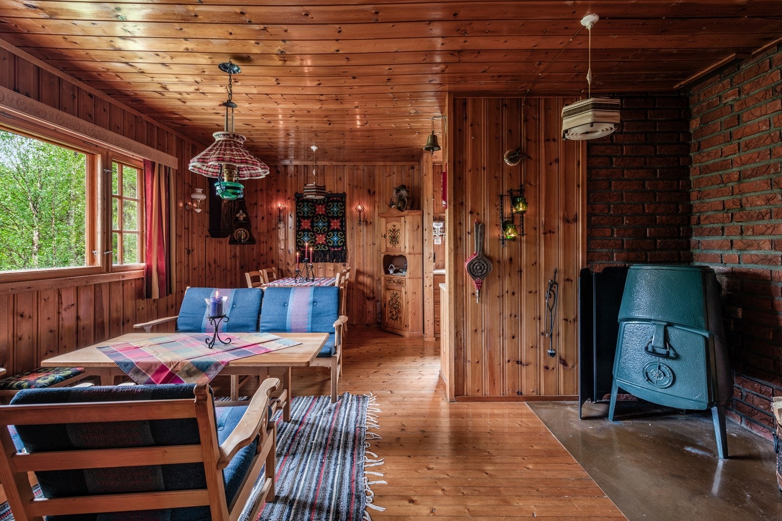 Lun stue med naturlig lys, peisovn og store vinduer. Perfekt for avslapning og hygge året rundt. Galleribilde