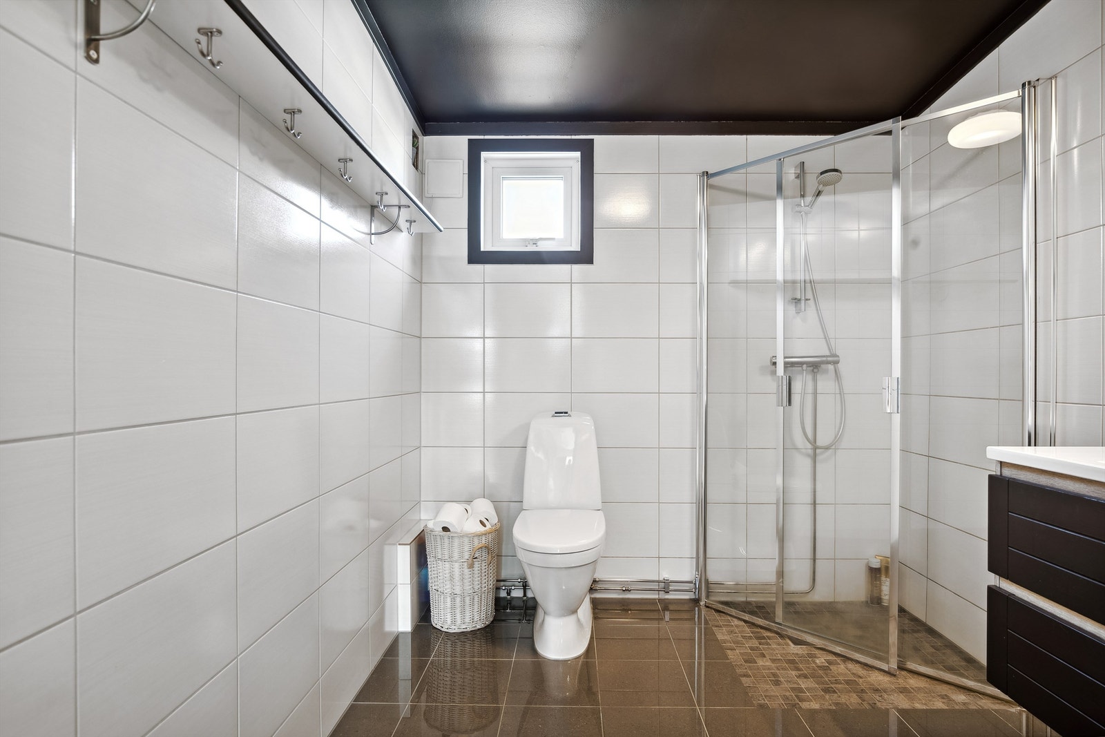 Lekkert flislagt bad fra 2018 med gulvmontert wc og dusjhjørne med innfellbare glassdører. Galleribilde