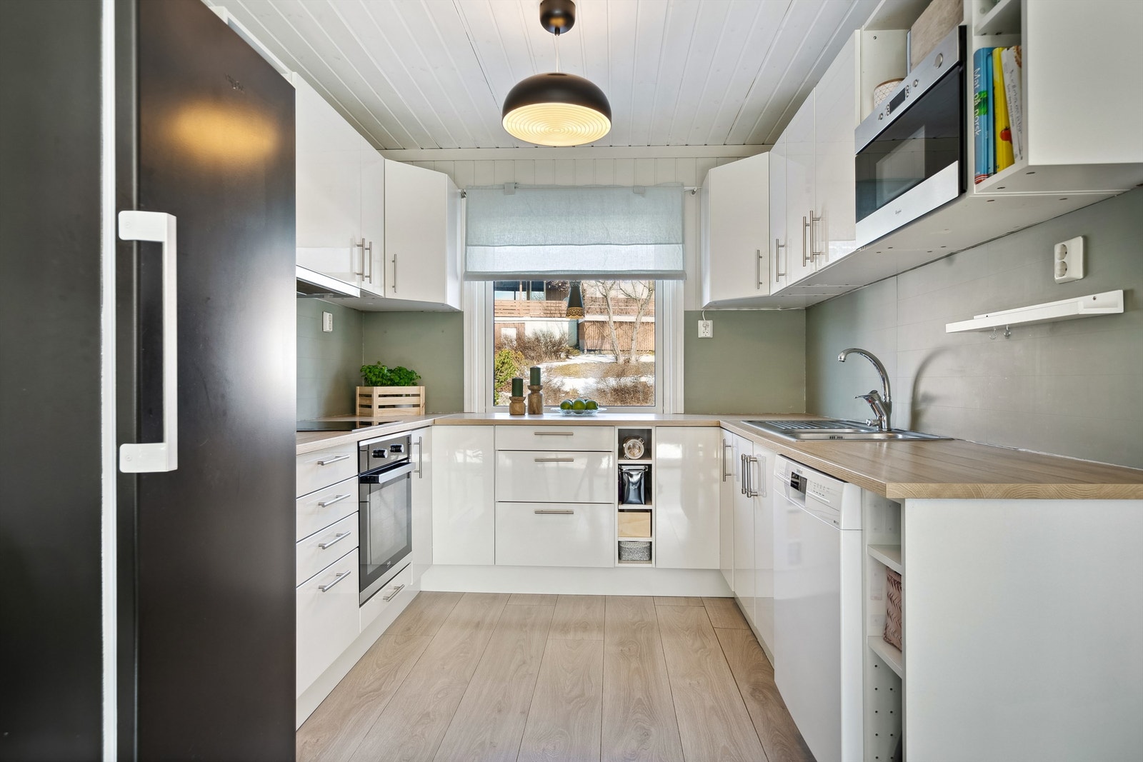 Kjøkkenet har en stilig, høyglanset innredning med integrert stekeovn, koketopp og micro. Galleribilde