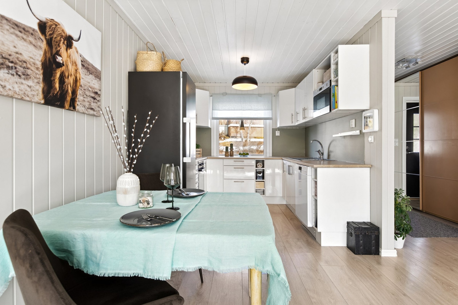 Her er det åpen løsning mellom stue, kjøkken og gang som gir rommet naturlig lys fra flere kanter. Galleribilde