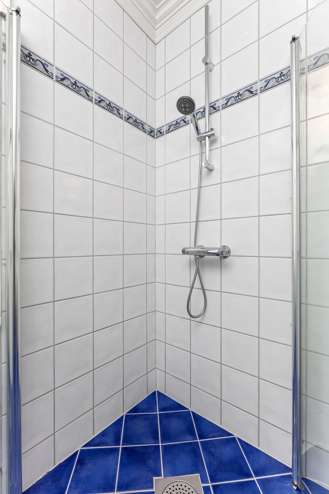 Videre er det montert gulvstående toalett og dusjhjørne med svingbare dører i glass. Galleribilde