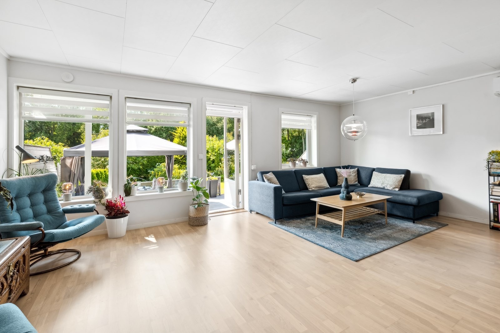 Lyst og innbydende spisestueområde med moderne belysning og store vinduer som slipper inn rikelig med naturlig lys. Galleribilde