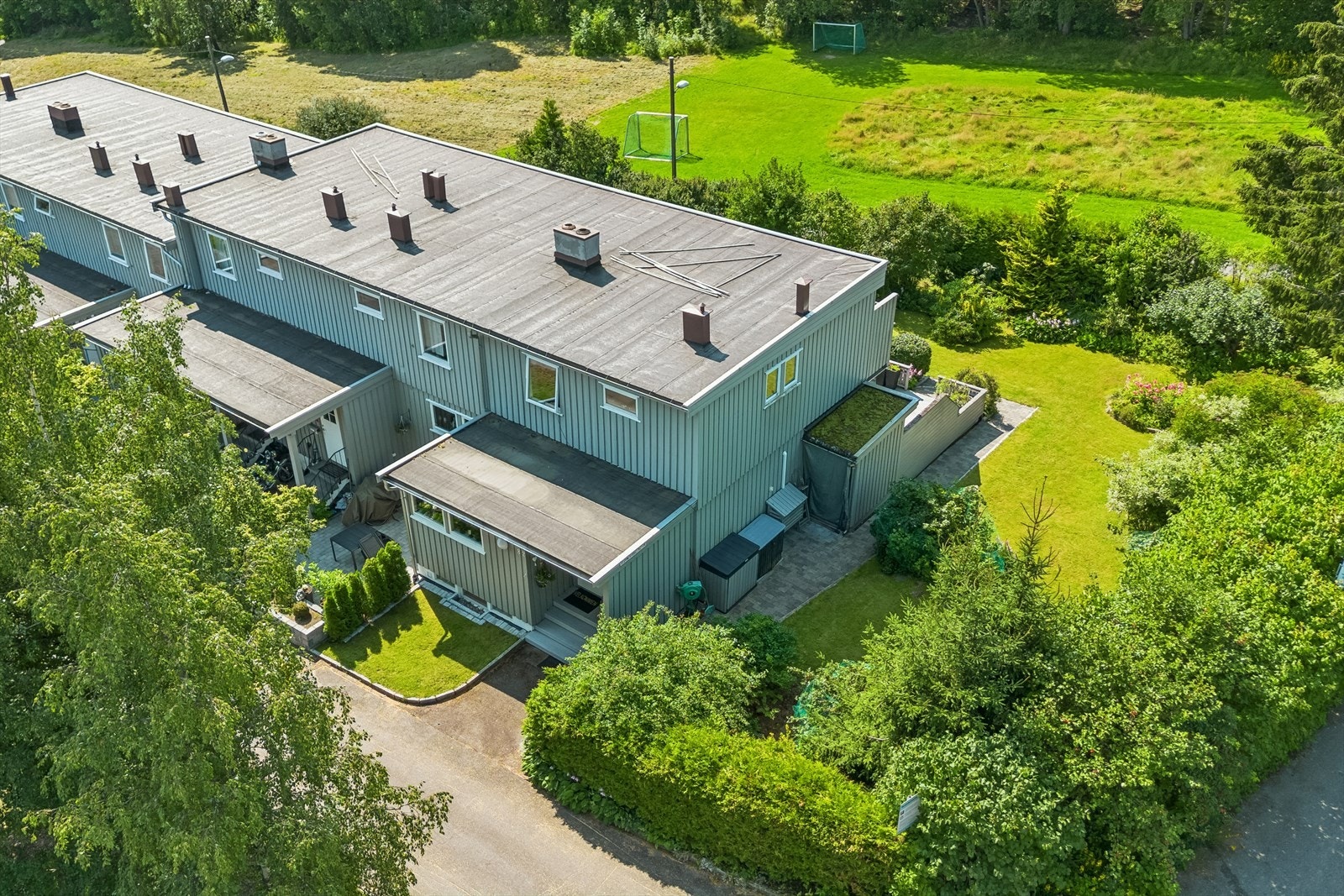 Droneperspektiv som fremhever den private og fredelige hagen sammen med terrassen. Galleribilde