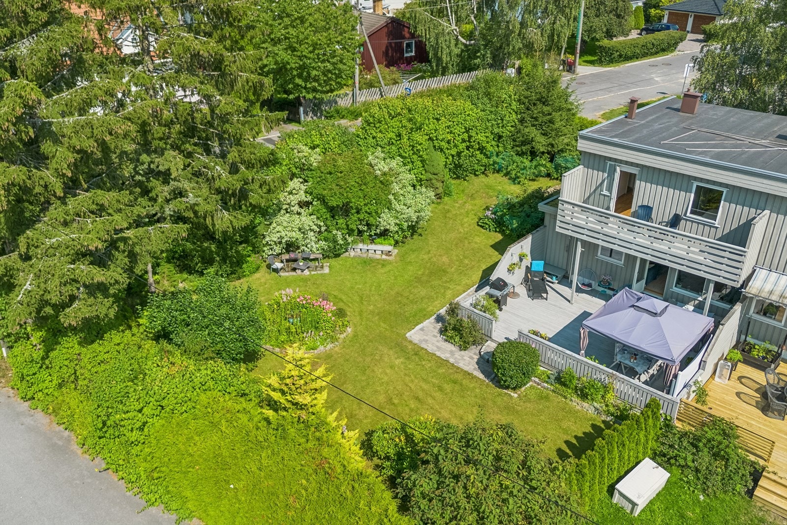 Fantastisk dronebilde som viser den romslige vestvendte terrassen og den skjermede hagen. Galleribilde