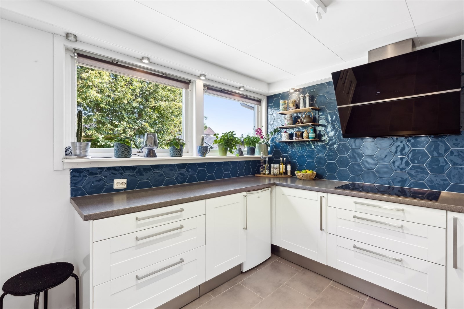 Kjøkkenventilator med sort glassfront og avtrekk ut. Nye overskap og fliser over kjøkkenbenk, samt byttet kjøkkenventilator og kjøleskap i 2018. Galleribilde