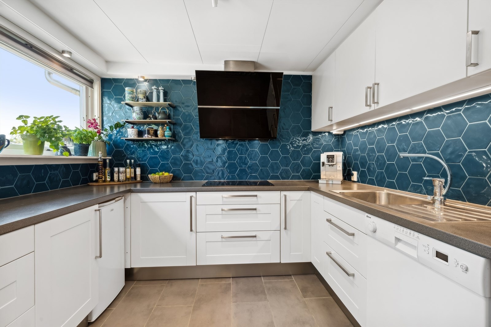 IKEA kjøkkeninnredning med hvite profilerte og hvite glatte fronter. Grå laminerte benkeplater. Galleribilde