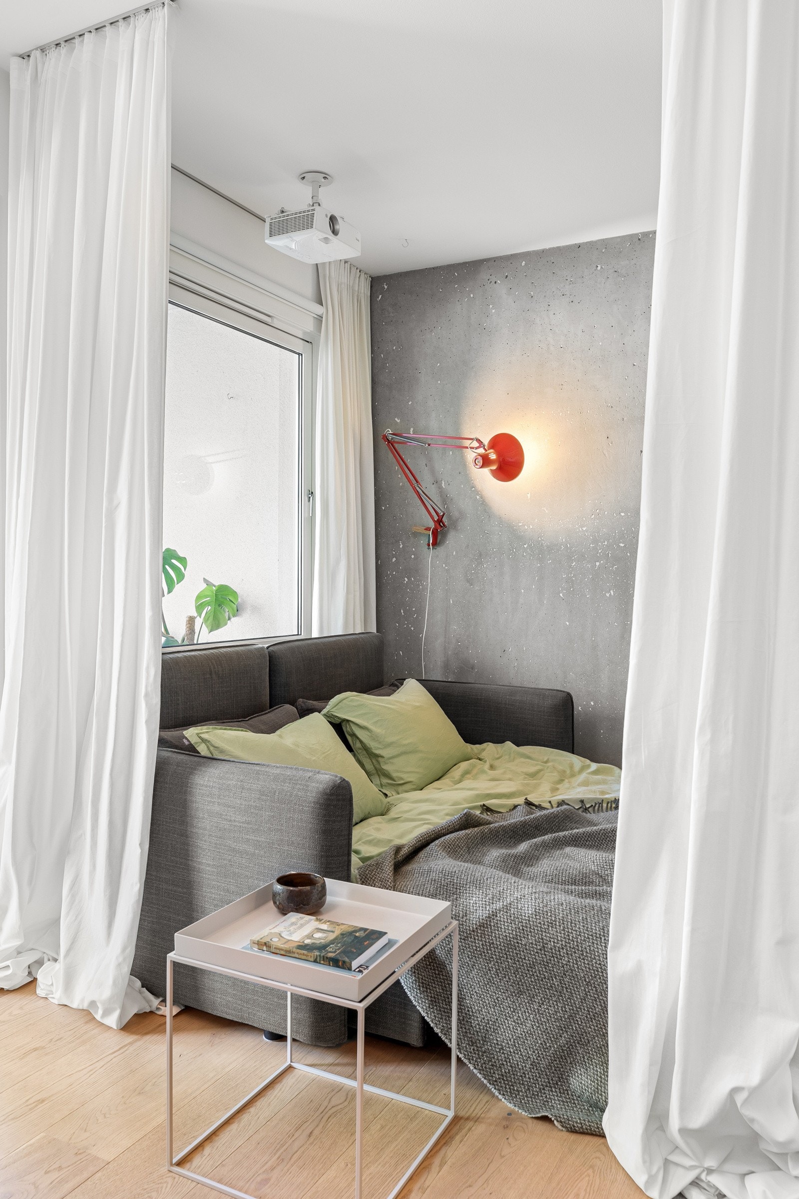 Her er sofaen i stuen gjort om til ekstra soveplass, praktisk adskilt med takhengde gardiner Galleribilde