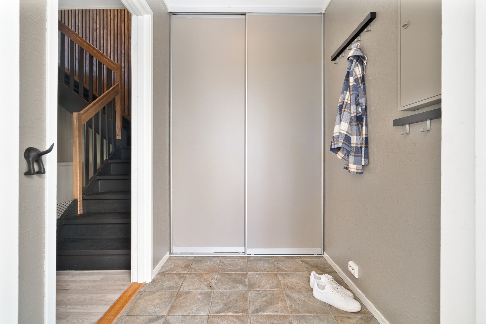 Romslig entre med god plass til å henge fra seg yttertøy i skyvedørsgarderoben. Galleribilde
