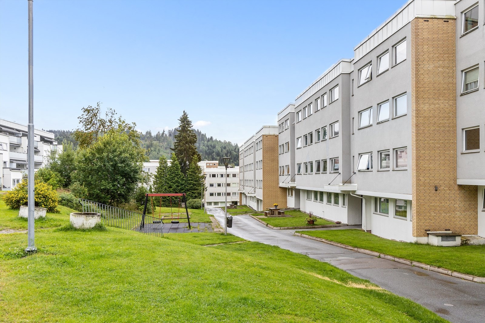 Mellom bygningene er det lekestativer og sittebenker til felles anvendelse. Galleribilde