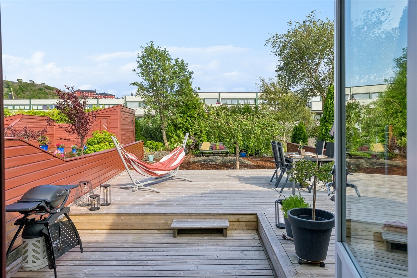 Herlig hage og terrasse/uteplass i bakkant av huset, med utgang fra kjøkken Galleribilde