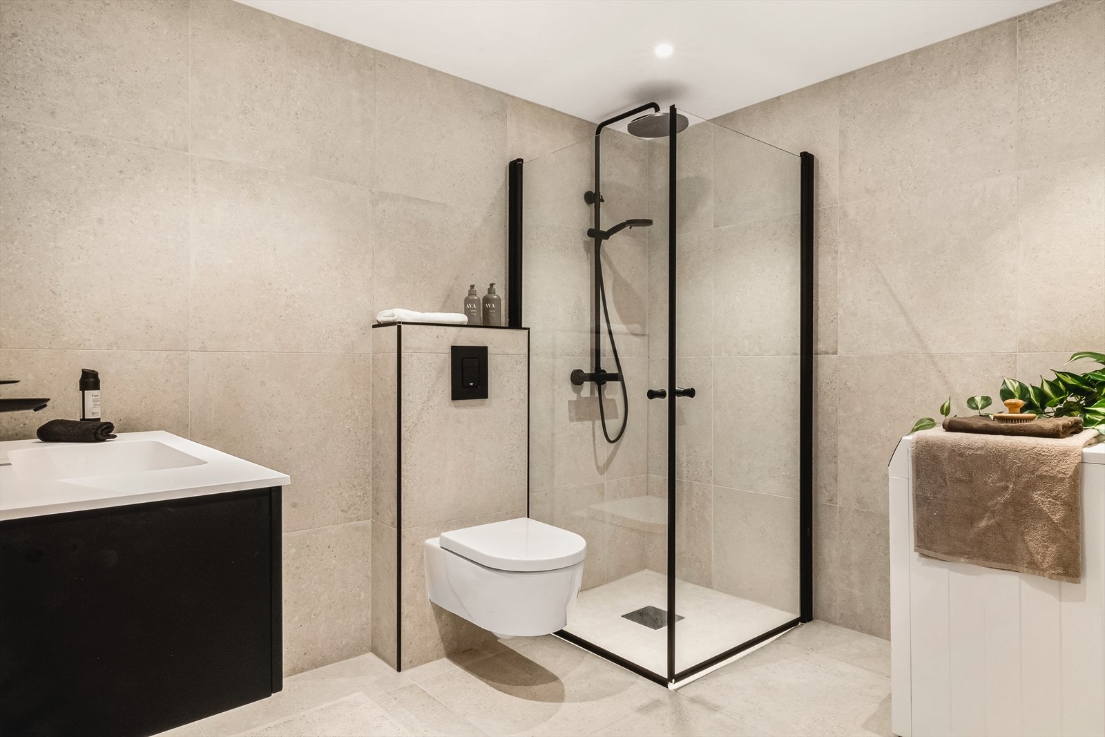 Delikat og moderne bad som har blitt oppusset i 2024. Badet har innredning med vegghengt toalett, helstøpt servant, skuffer under servant med profilerte fronter, dusjdører i klart glass og opplegg for vaskemaskin. Galleribilde